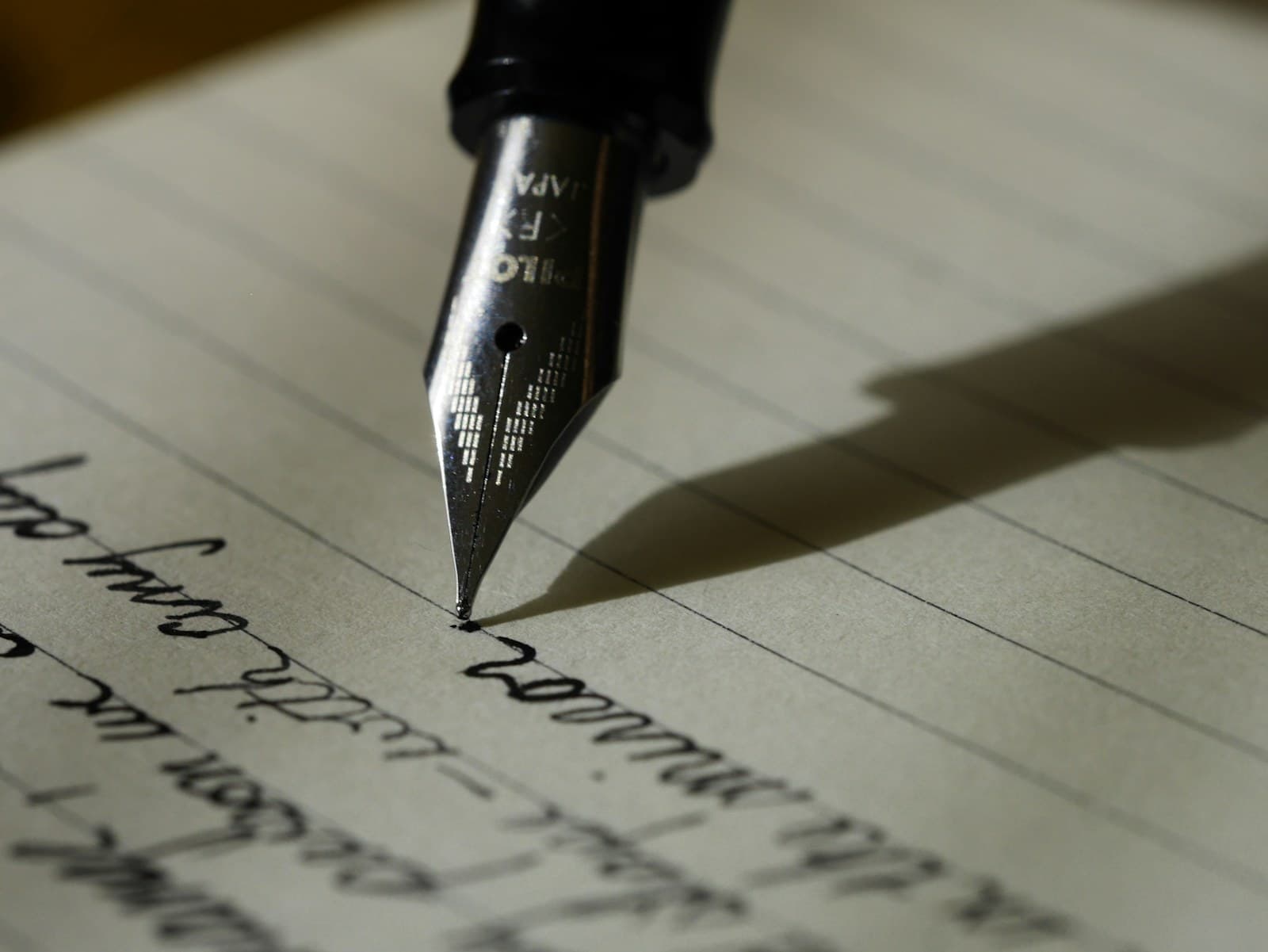 A fountain pen writing considered notes on warm-toned paper